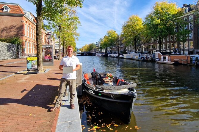 Amsterdam Canal Tour by Open Boat – 90 min Small Group Experience - De Wallen canal edge: small canals, old churches, and the red-light history framing